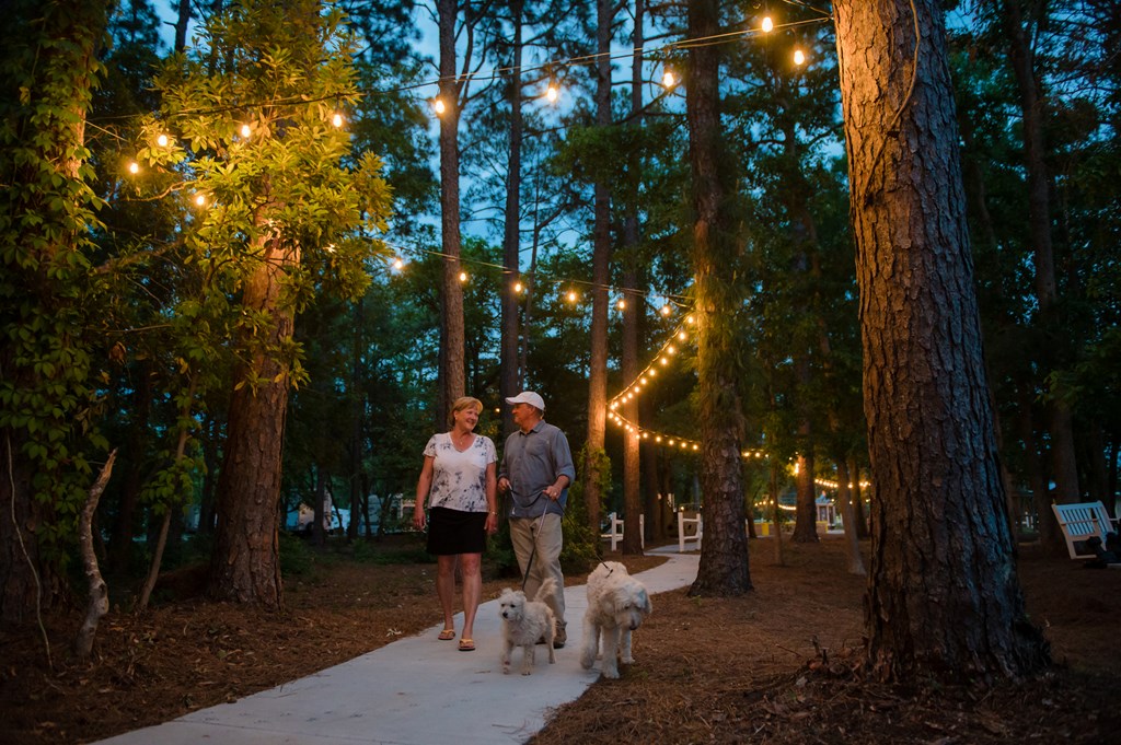 A couple walks down a lit path during an evening on a KOA campground.