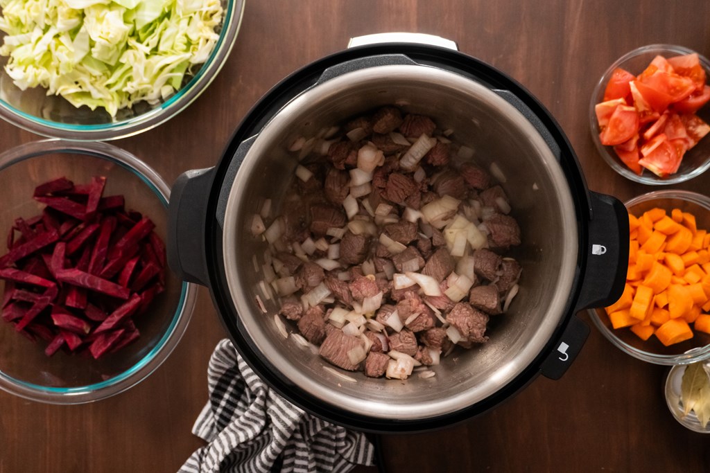 Top down view of ingredients being put in an instant pot cooker.
