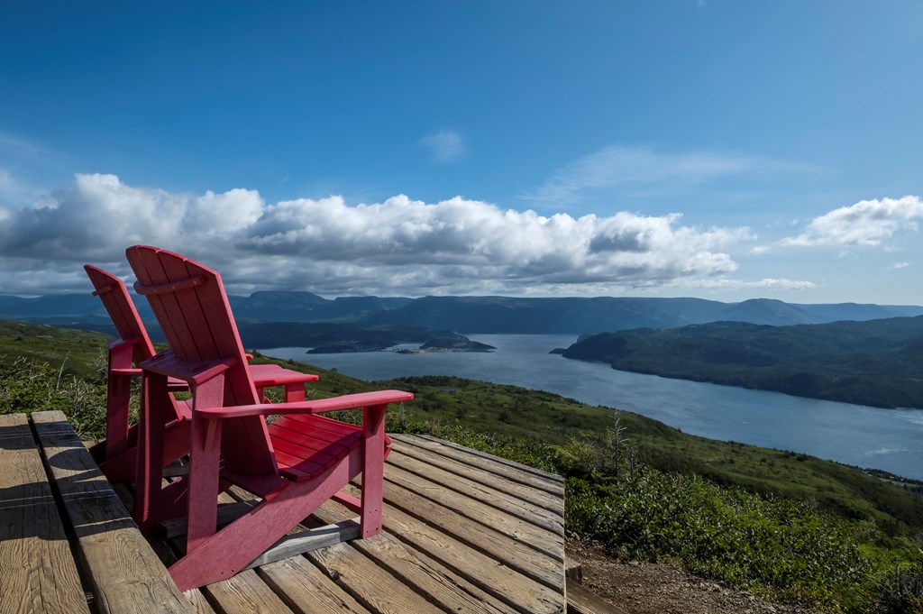 Two Red Adirondack Chairs on Top of the Lookout Trail in Gros Morne National Park Newfoundland.