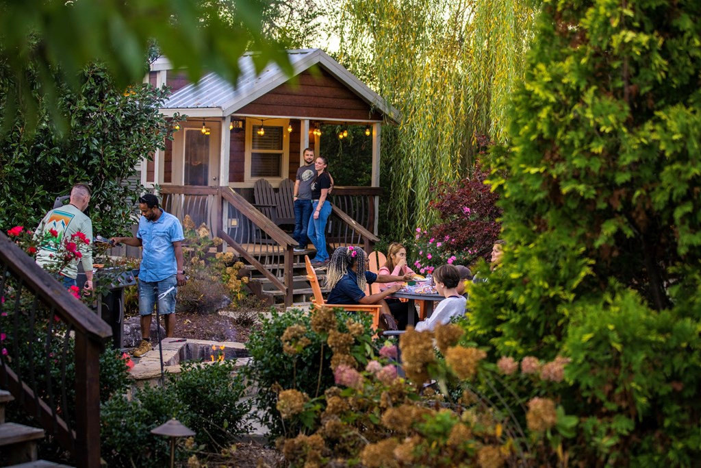 A family gathers at a Deluxe Cabin on a KOA campground.
